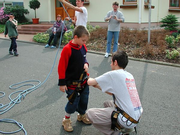 hier junge beim anziehen des klettergurtes